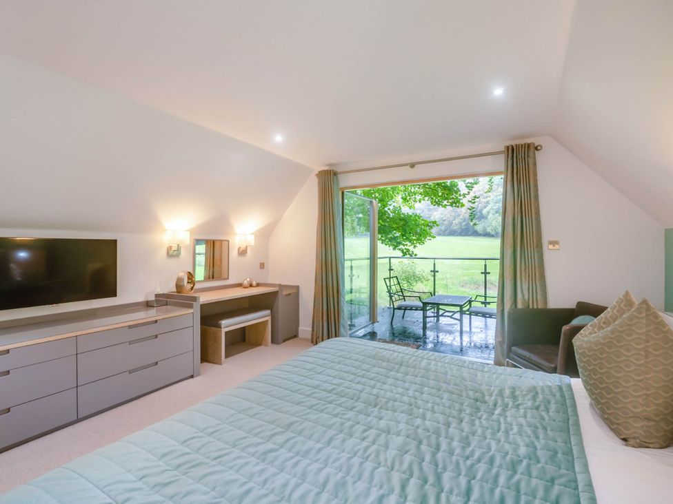 A bedroom with a television and balcony at St Austell Lodge Spa in Praze-An-Beeble