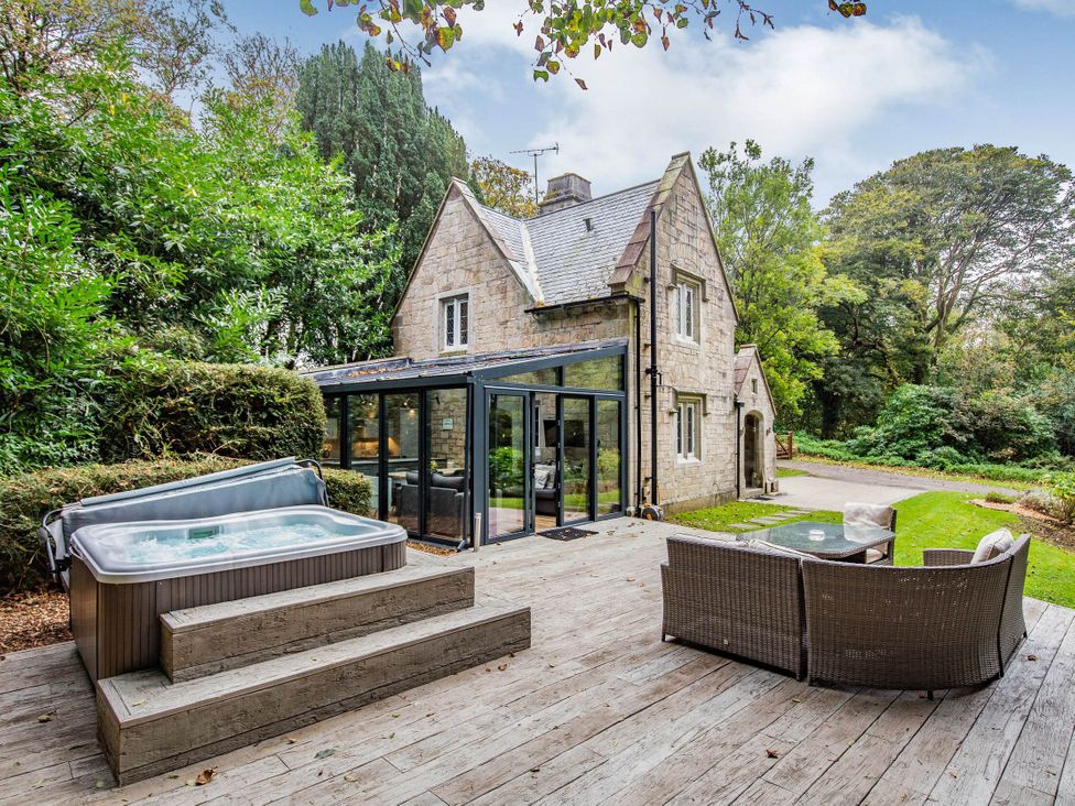 An outdoor area with a hot tub and seating at The Gatehouse in Praze-An-Beeble