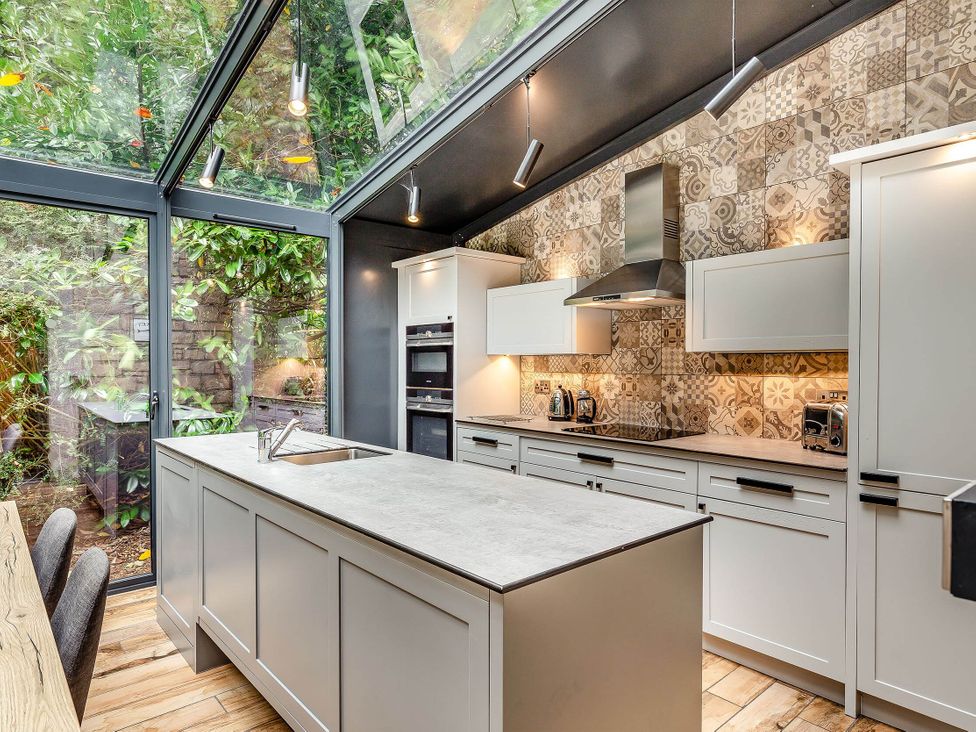 A kitchen with cabinets and kitchen island at The Gatehouse in Praze-An-Beeble
