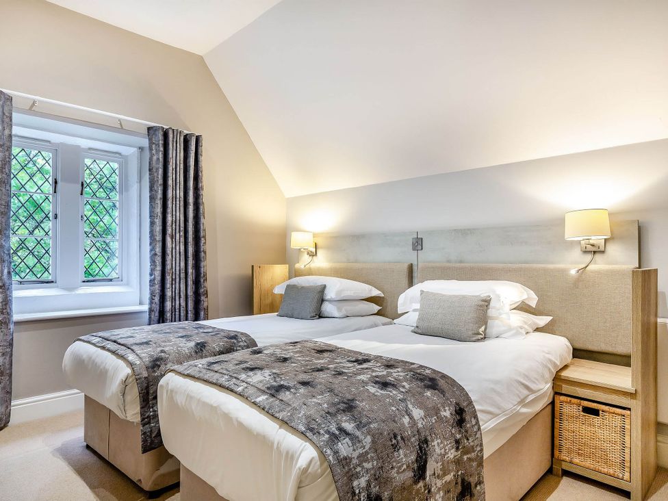 A bedroom with twin beds and a window at The Gatehouse in Praze-An-Beeble