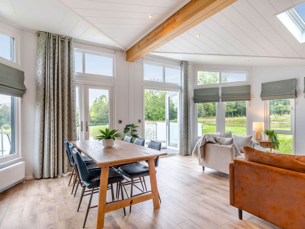 A living room with a table and chairs at Lake View Spa in Praze-An-Beeble
