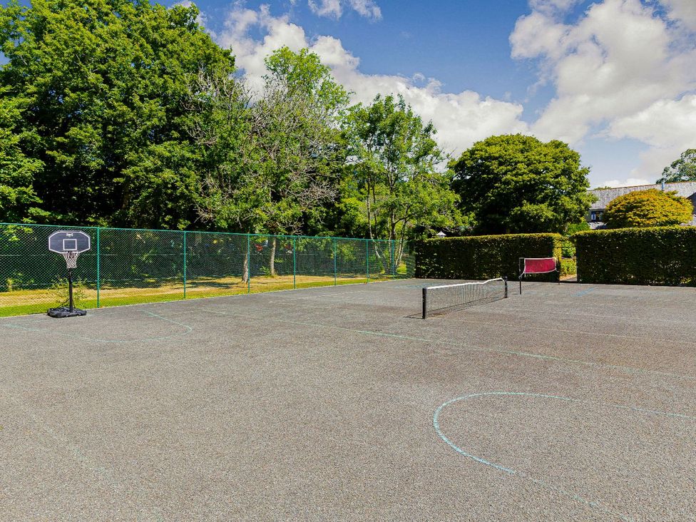 An outdoor sports area with a basketball hoop and tennis court at Lake View Spa in Praze-An-Beeble