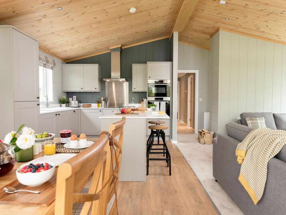 A kitchen with a dining table and sofa at Argel Spa in Praze-An-Beeble