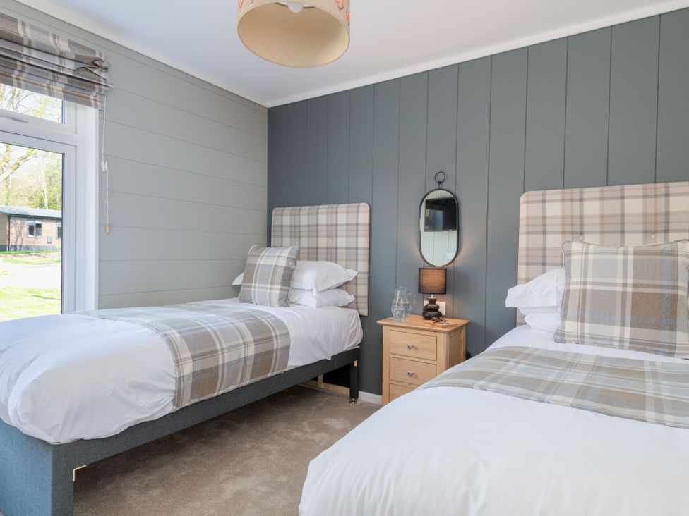 A bedroom with two beds and bedside table at Argel Spa, Praze-An-Beeble