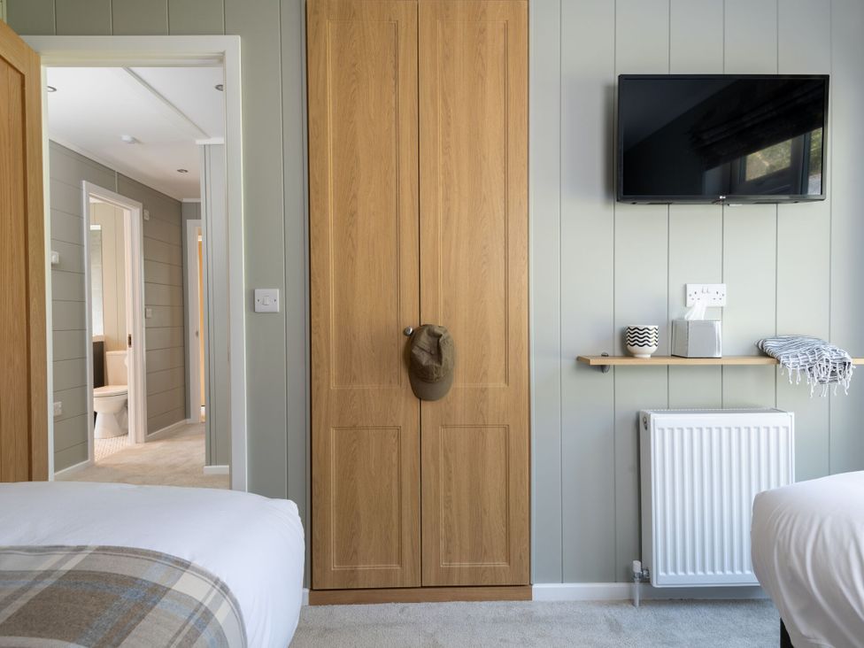 A bedroom with a wardrobe and television at Argel Spa in Praze-An-Beeble