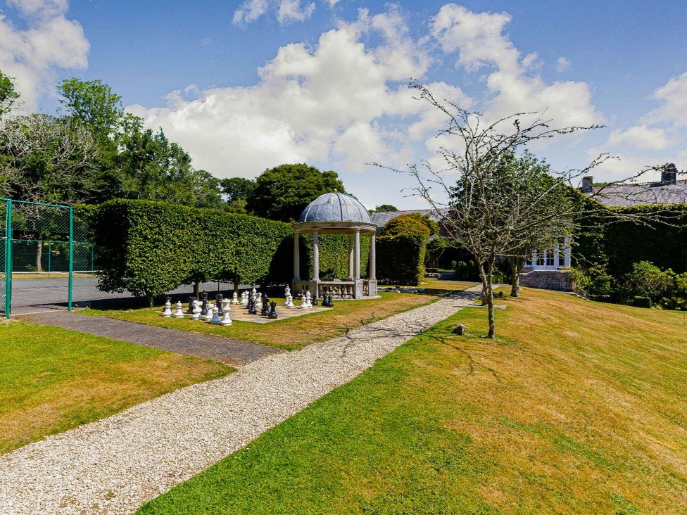 A garden with a gazebo and chess set at Argel Spa in Praze-An-Beeble