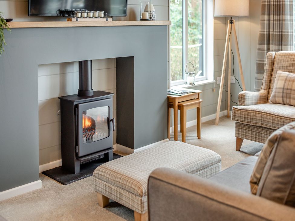 A living room with a fireplace and television at Argel Spa Pet Praze-An-Beeble