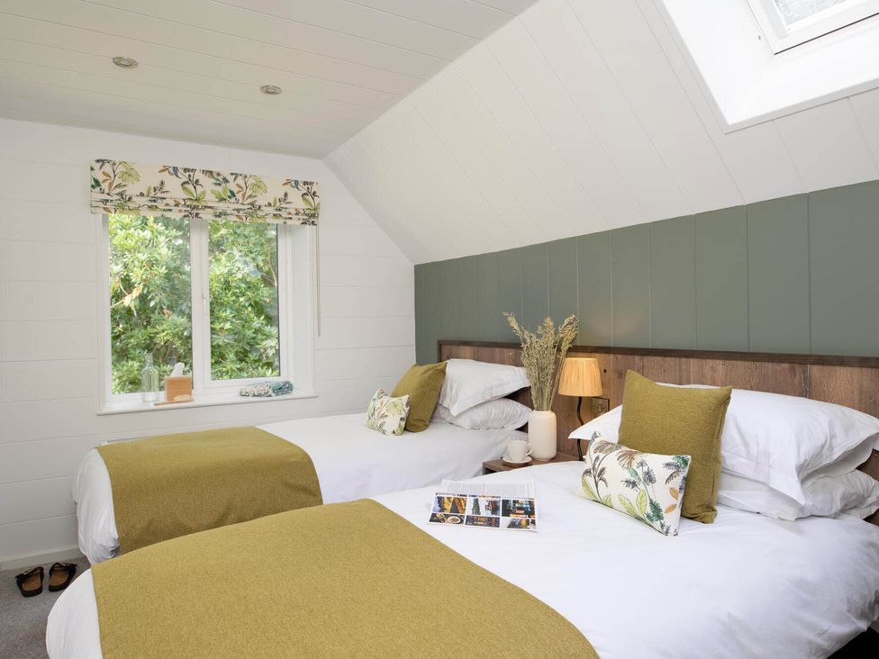 A bedroom with two beds and a window at Kilden Pet in Praze-An-Beeble