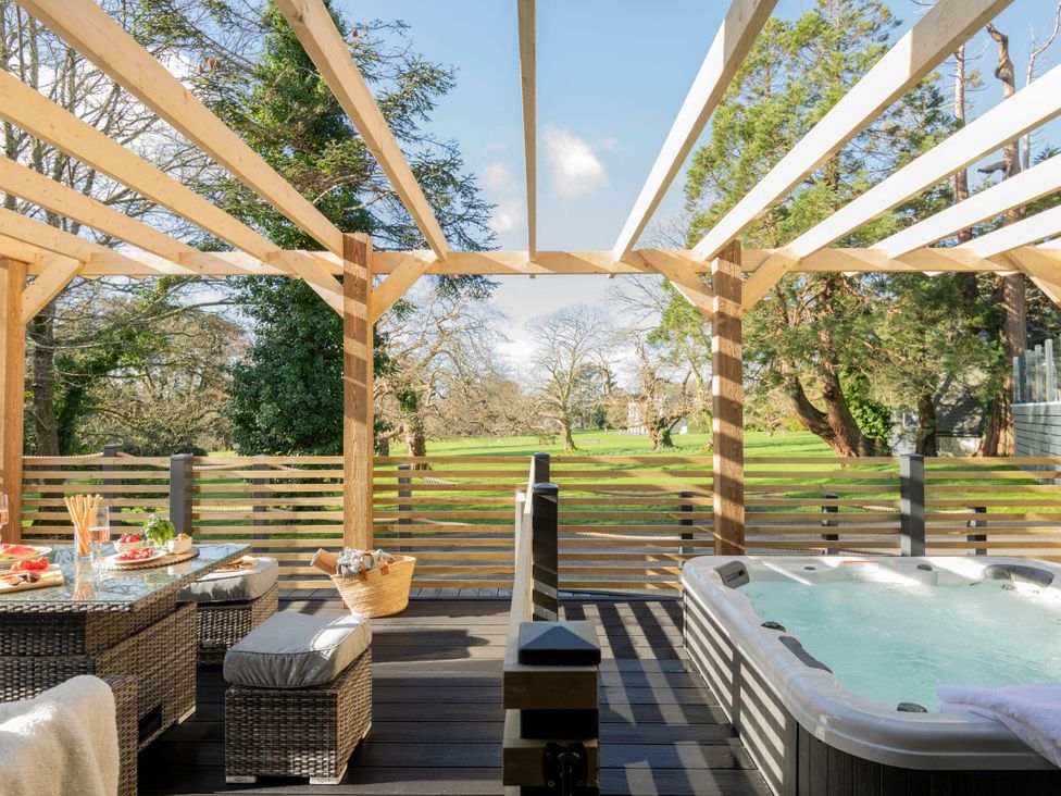 A garden with outdoor seating and a hot tub at Lowarth Lodge Spa Pet Praze-An-Beeble