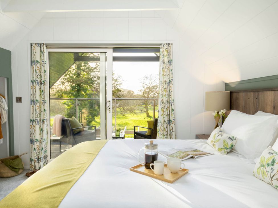 A bedroom with a bed and coffee setup at Lowarth Lodge Spa Pet Praze-An-Beeble