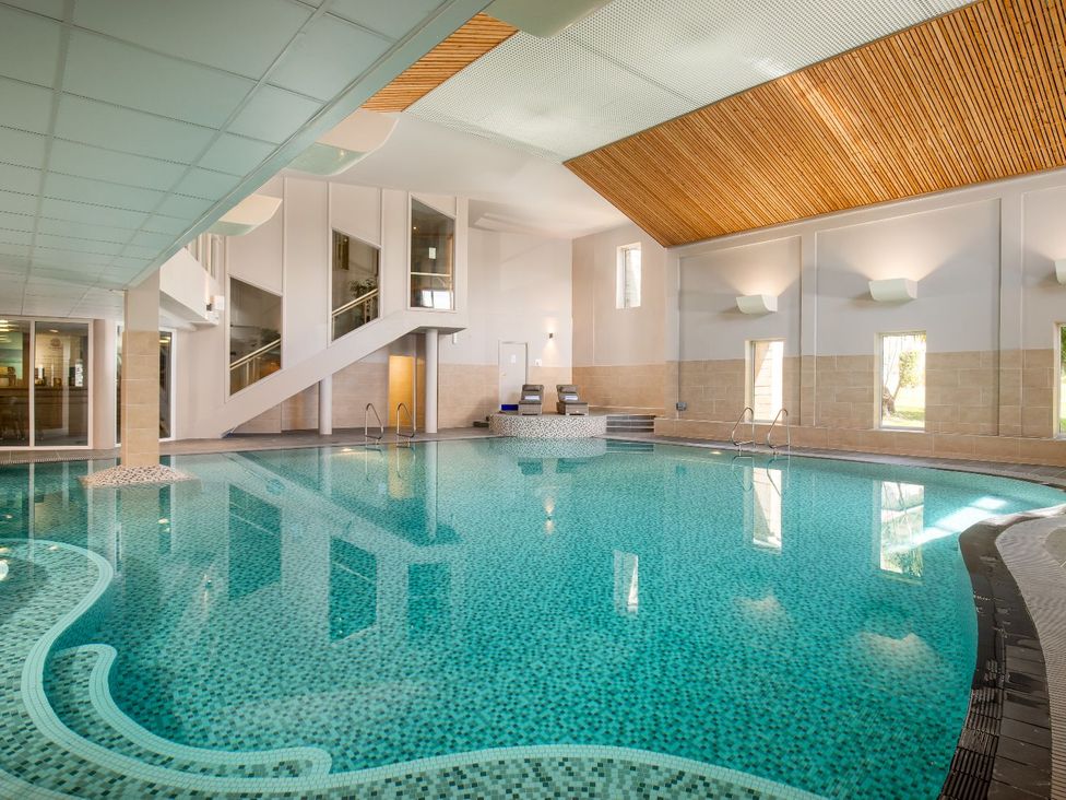 An indoor pool with lounge chairs at Lowarth Lodge Spa Pet in Praze-An-Beeble