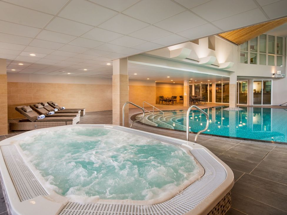 A spa area with a hot tub and swimming pool at Lowarth Lodge Spa Pet, Praze-An-Beeble