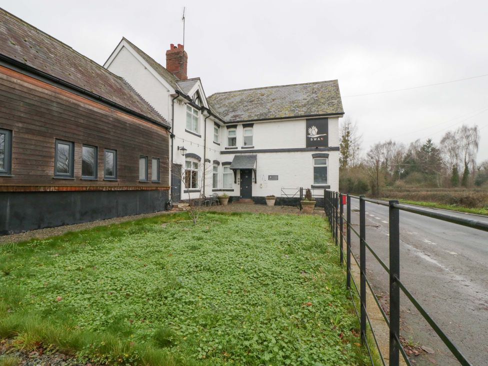 A building with a sign and fence at The Swan