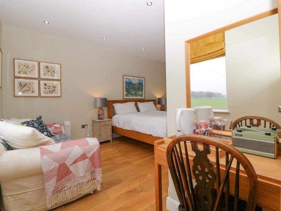 A bedroom with a bed, table, and sofa at The Swan in Whitney-On-Wye