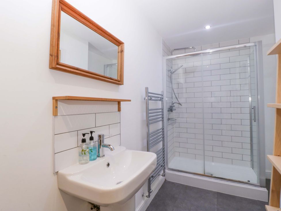A bathroom with a sink, mirror, shower, and towel rail at The Swan in Whitney-On-Wye