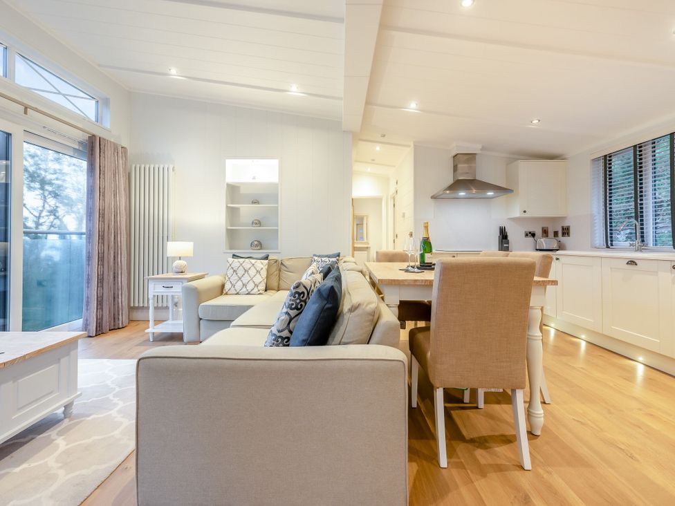 A living room with a sofa and dining area at Milk Wood 2 in Laugharne