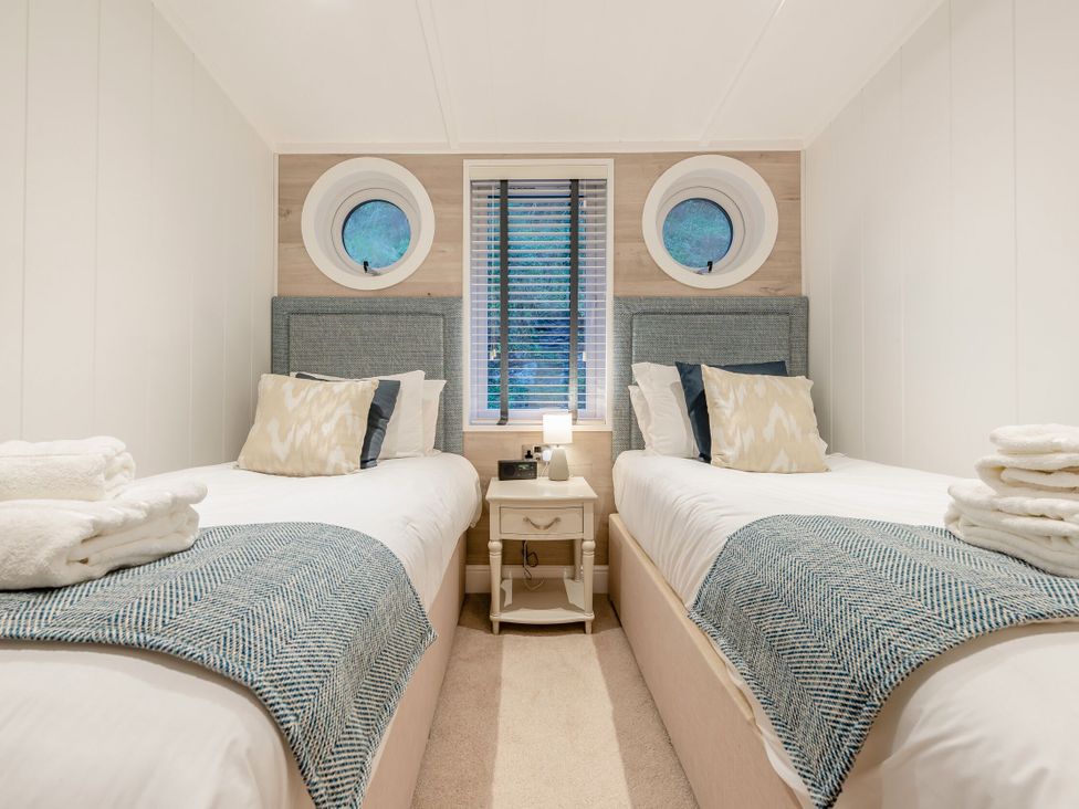 A bedroom with twin beds and a window at Milk Wood 2 in Laugharne