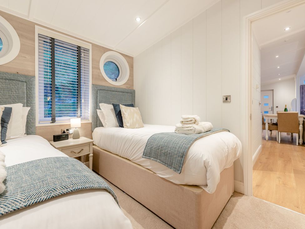 A bedroom with two beds and a nightstand at Milk Wood 2 in Laugharne