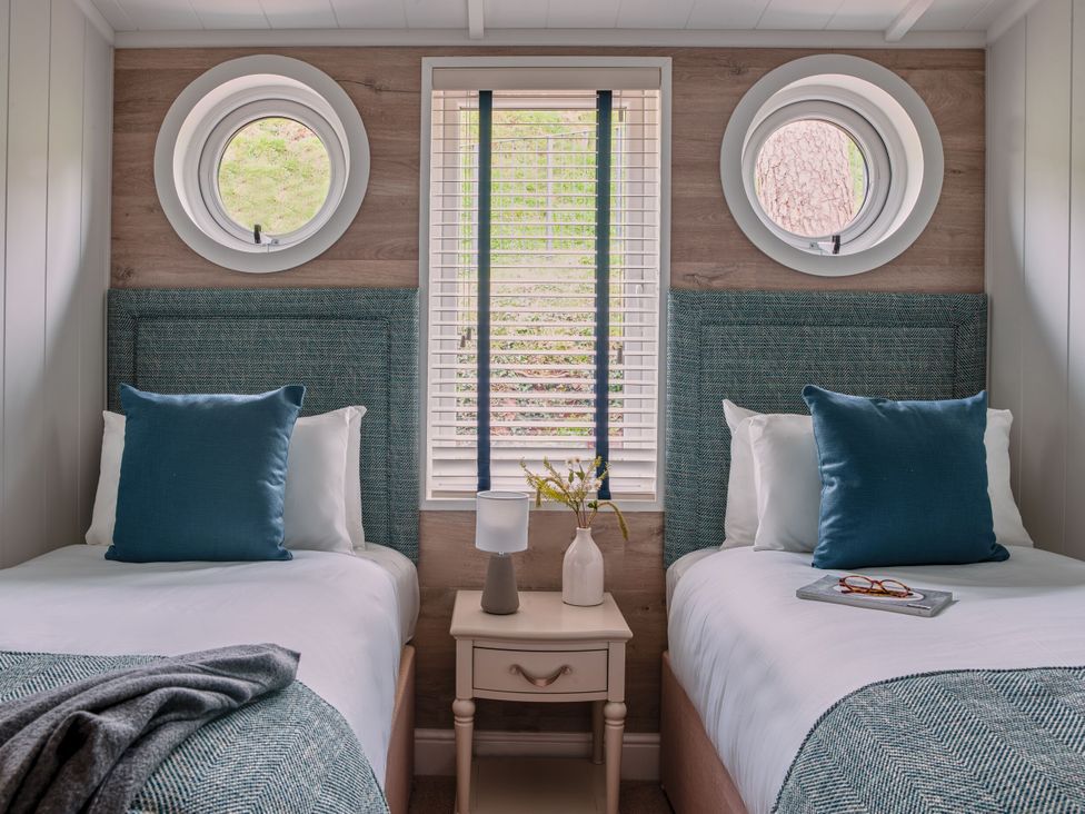 A bedroom with two beds and a window at Milk Wood 2 Spa in Laugharne