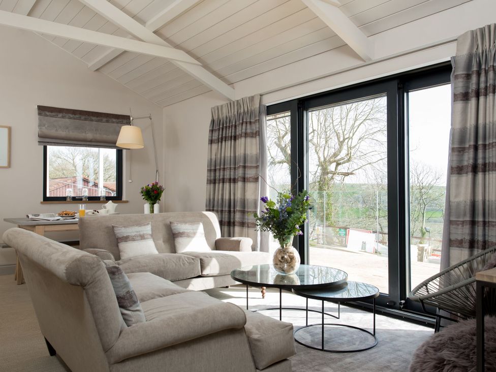 A living room with a sofa and dining table at Dylan Spa in Laugharne