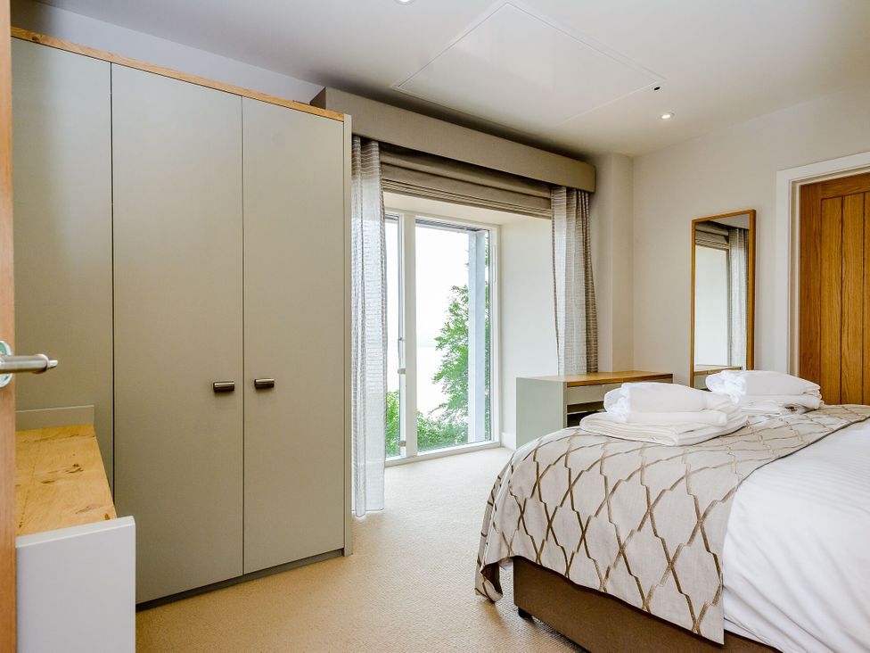 A bedroom with a bed and wardrobe at The View in Laugharne