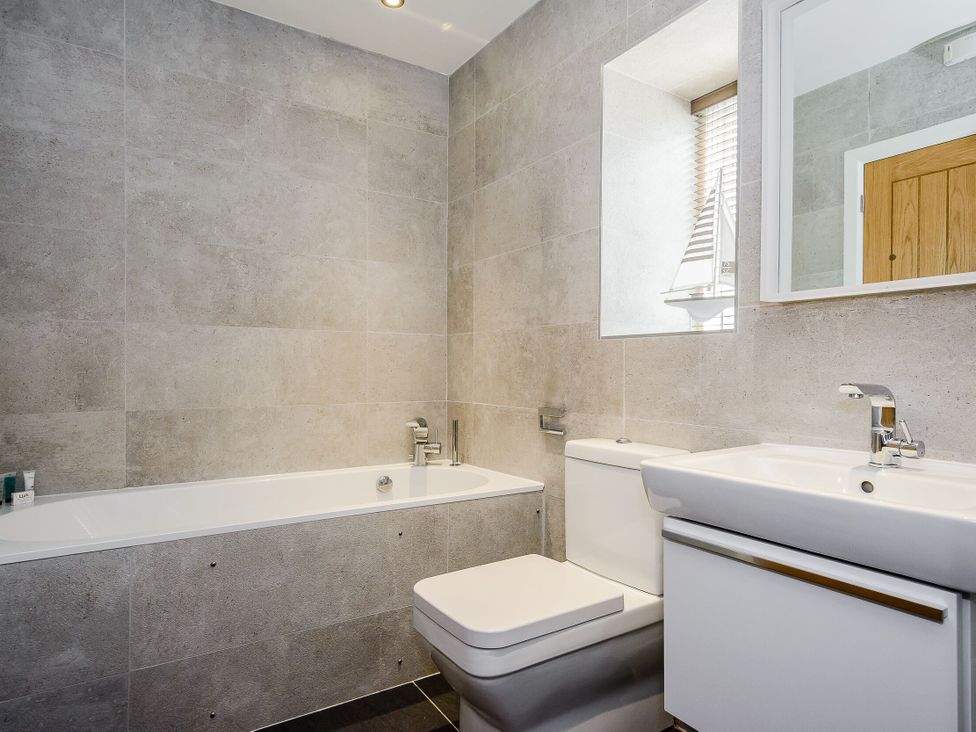A bathroom with a bath tub, toilet, and sink at The View in Laugharne