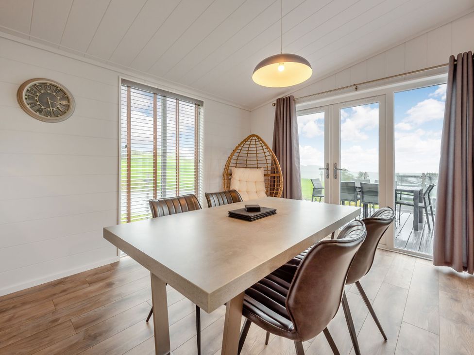 A dining room with a table and chairs at Sonnet 2 Spa in Laugharne