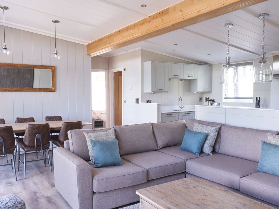 A living room with a sofa and dining area at Milk Wood 3 in Laugharne