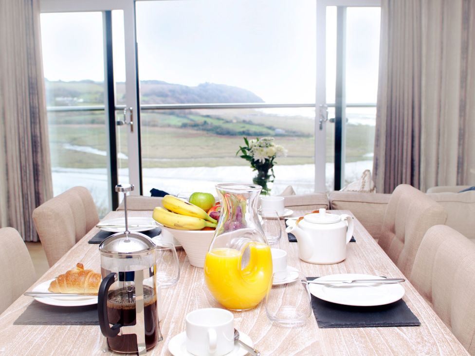 A dining room with a table set for breakfast at Milk Wood 3 in Laugharne