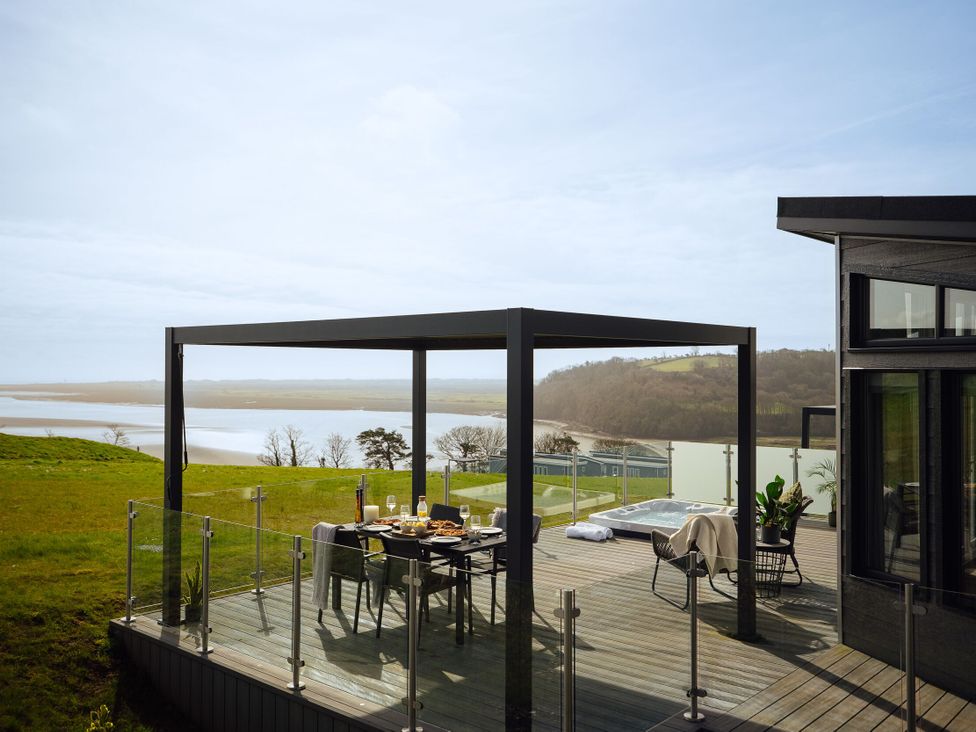 An outdoor dining area with a view at Apex Spa in Laugharne