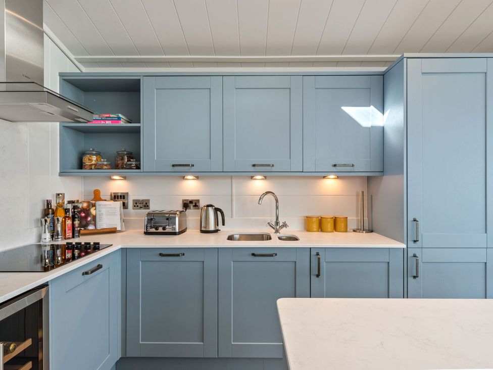 A kitchen with cabinets, sink, and appliances at Apex Spa in Laugharne