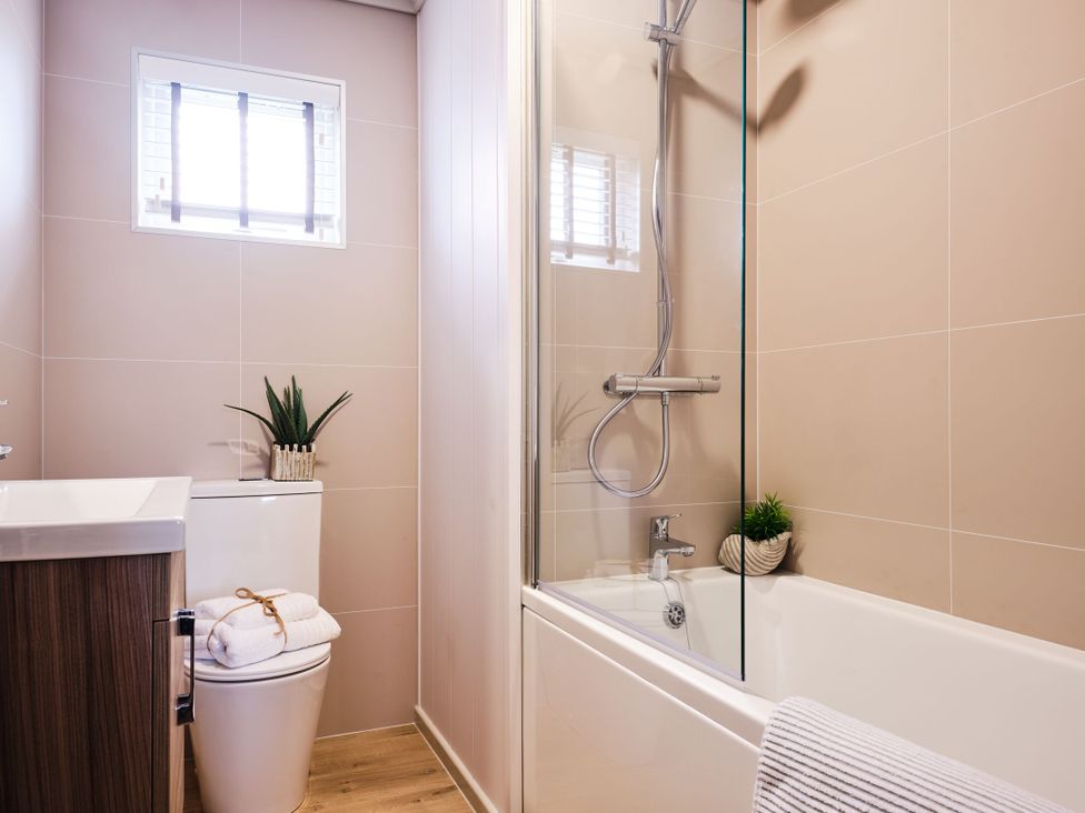 A bathroom with a toilet, bathtub, and shower at Epic Spa in Laugharne