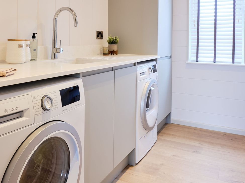 A laundry room with washing machines and a sink at Epic Spa in Laugharne