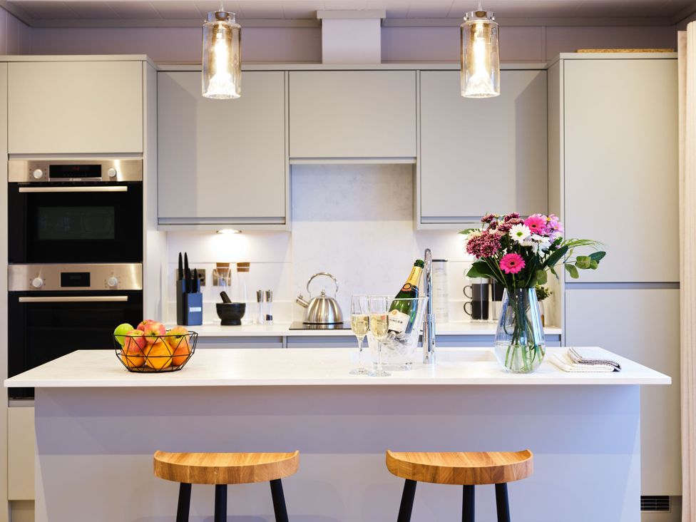 A kitchen with barstools and a fruit bowl at Epic Spa in Laugharne