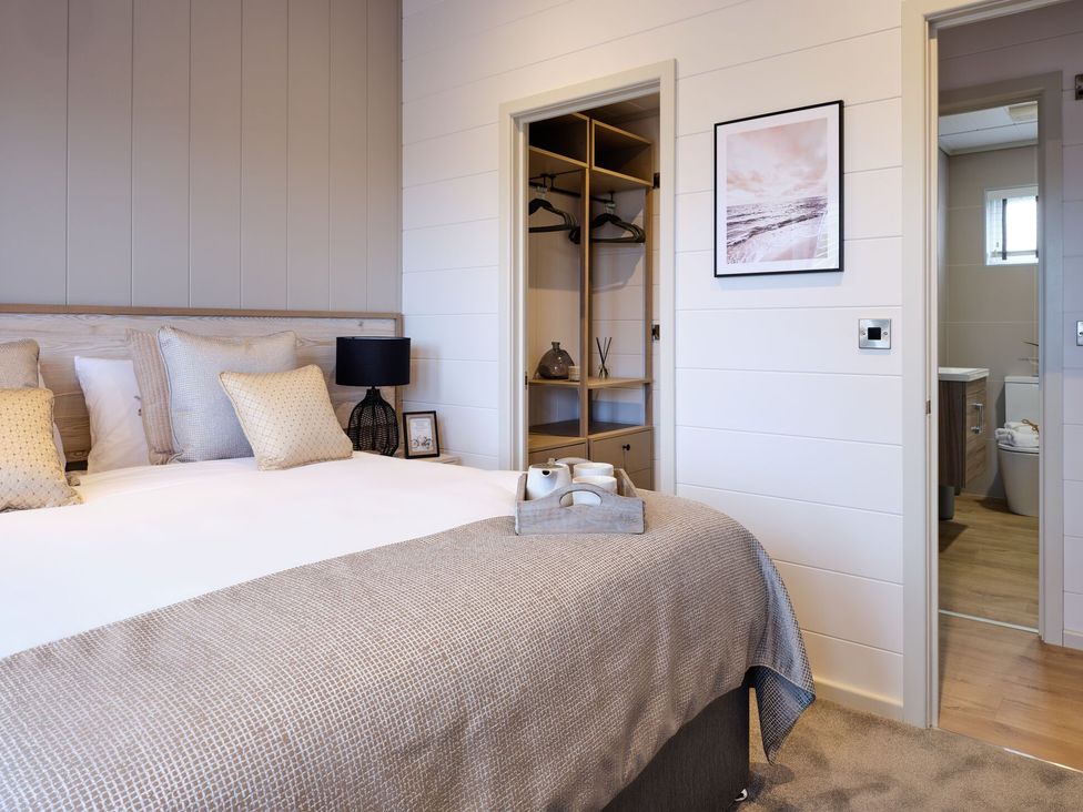 A bedroom with a bed and wardrobe at Epic Spa (Pet) Laugharne