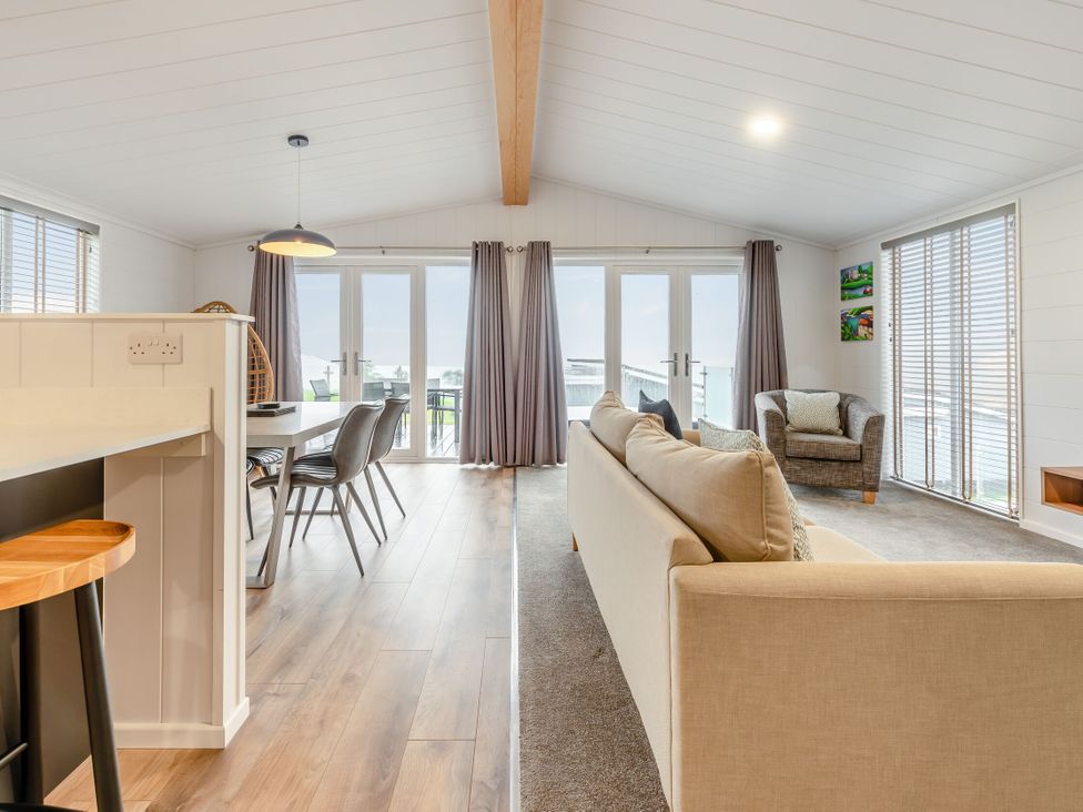 A living room with a sofa and dining area at Sonnet 3 Spa (Pet) Laugharne