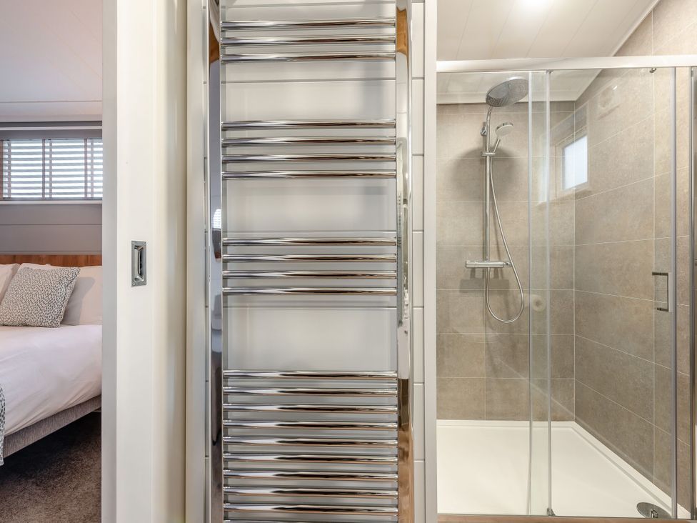 A bathroom featuring a shower and towel rail at Sonnet 3 Spa (Pet) (Roof Terrace) Laugharne