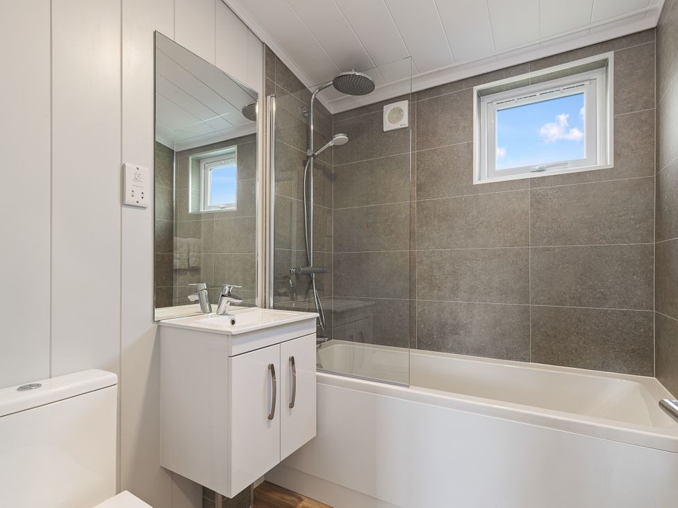 A bathroom with a bathtub and shower fixtures at Sonnet 3 Roof Terrace Spa Laugharne