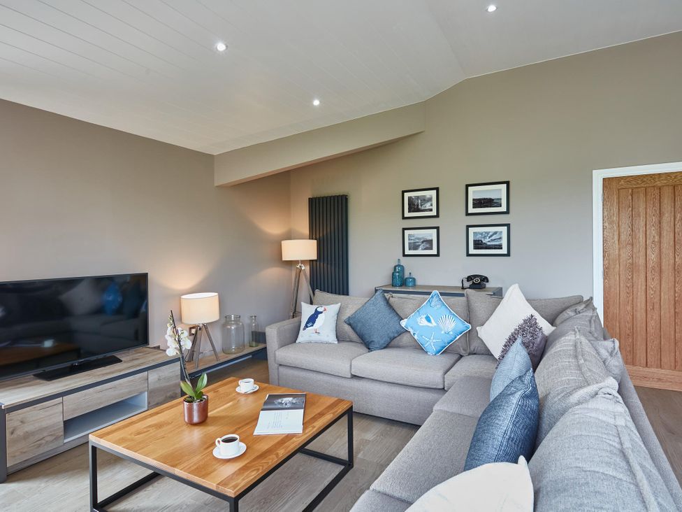 A living room with a sofa and coffee table at Glan Y Mor in Laugharne