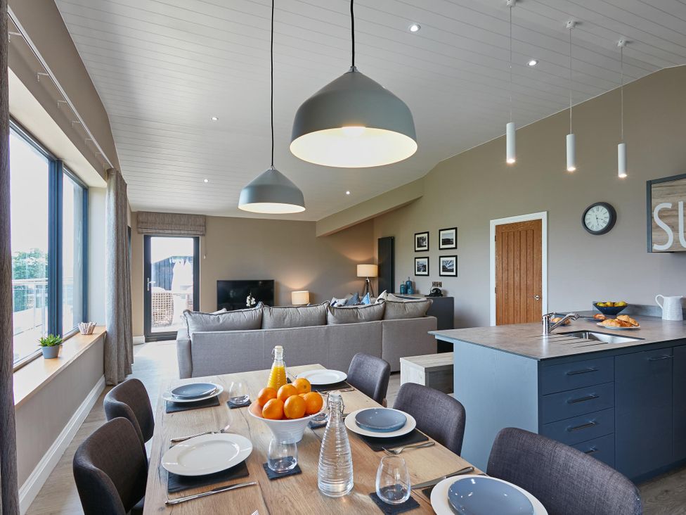 A living room with a dining table and sofa at Glan Y Mor in Laugharne