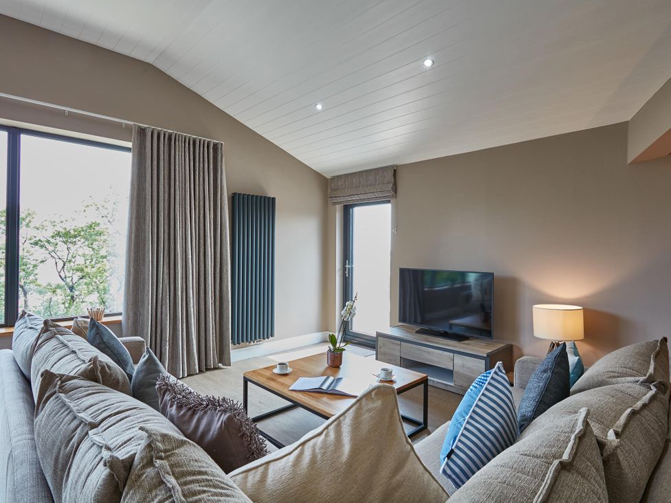 A living room with a sofa and a television at Glan Y Mor in Laugharne