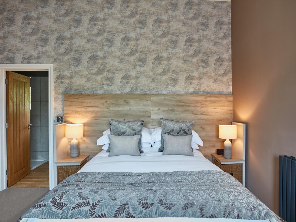 A bedroom with a bed and bedside tables at Glan Y Mor in Laugharne