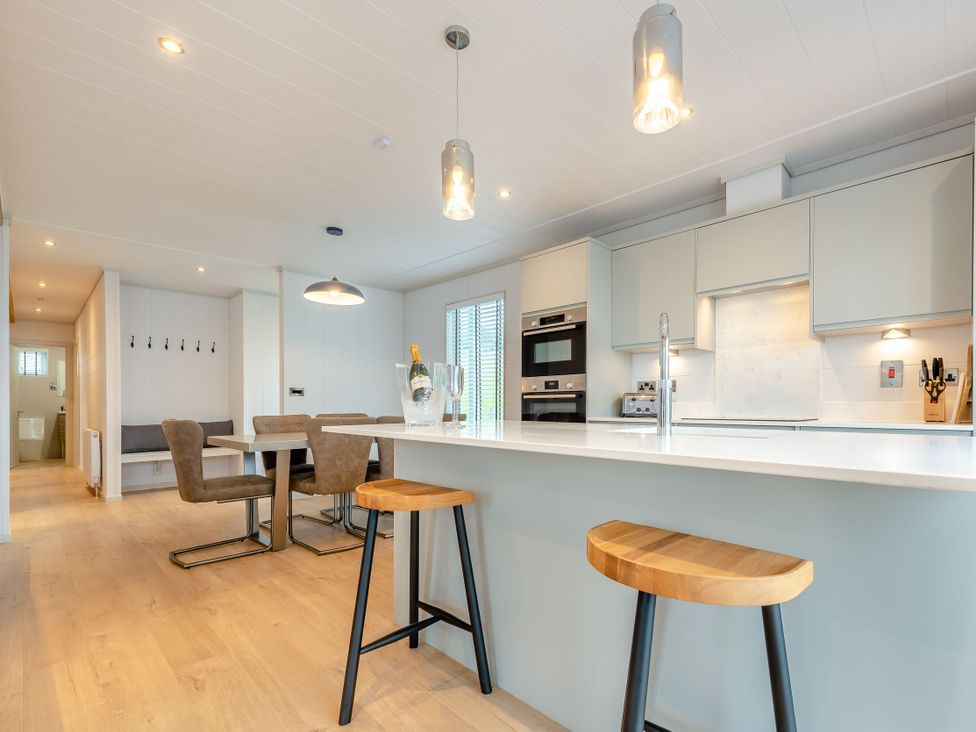 A kitchen with an island and stools at Epic Spa (Roof Terrace) Laugharne