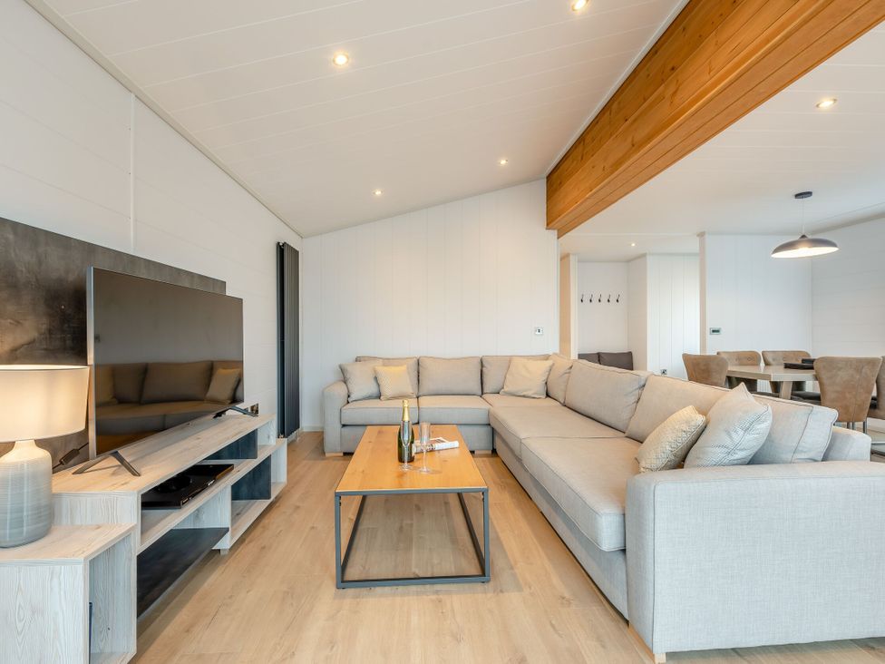 A living room with a sofa and television at Epic Spa (Roof Terrace) (Pet) in Laugharne