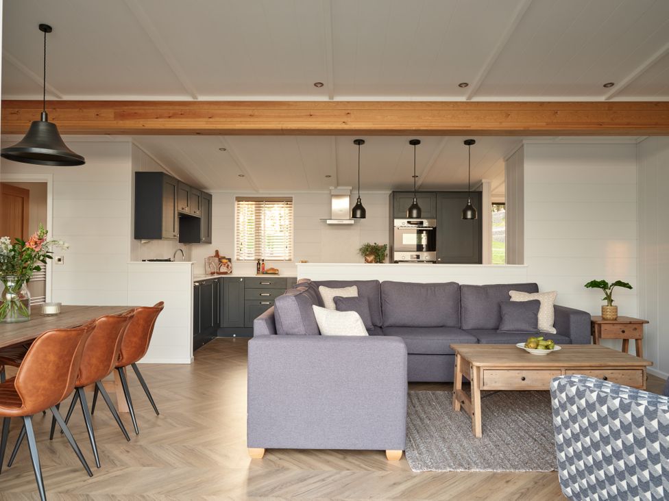 A living room with a sofa and dining area at Canto Spa in Laugharne