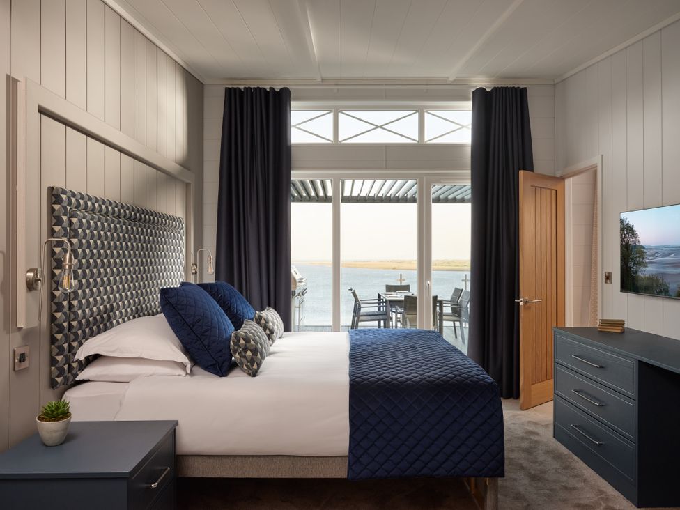 A bedroom with a bed and a view of the water at Canto Spa in Laugharne