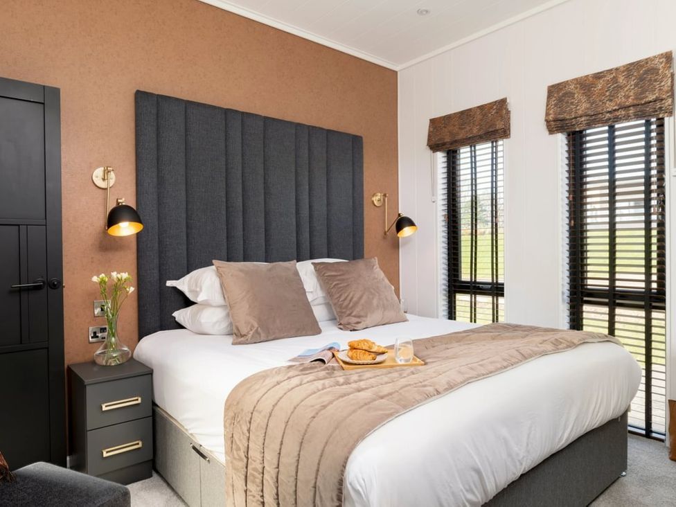 A bedroom with a bed and bedside table at Solace Laugharne