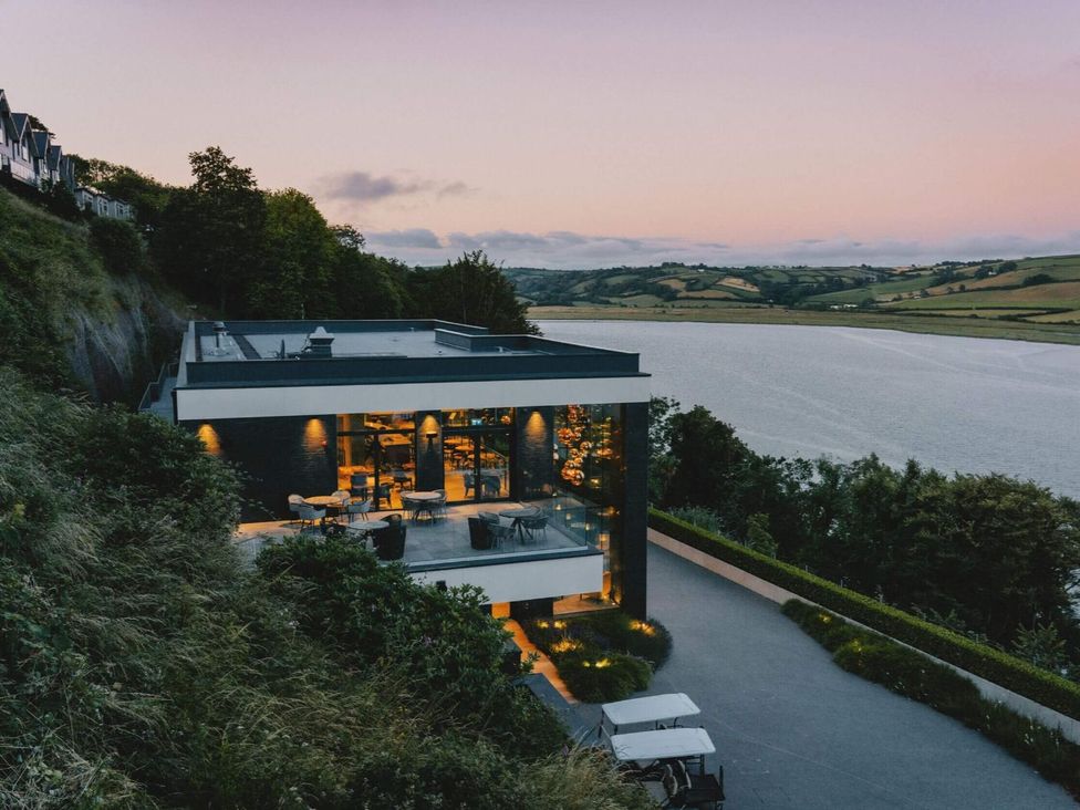 A house with a deck overlooking a river at Solace in Laugharne