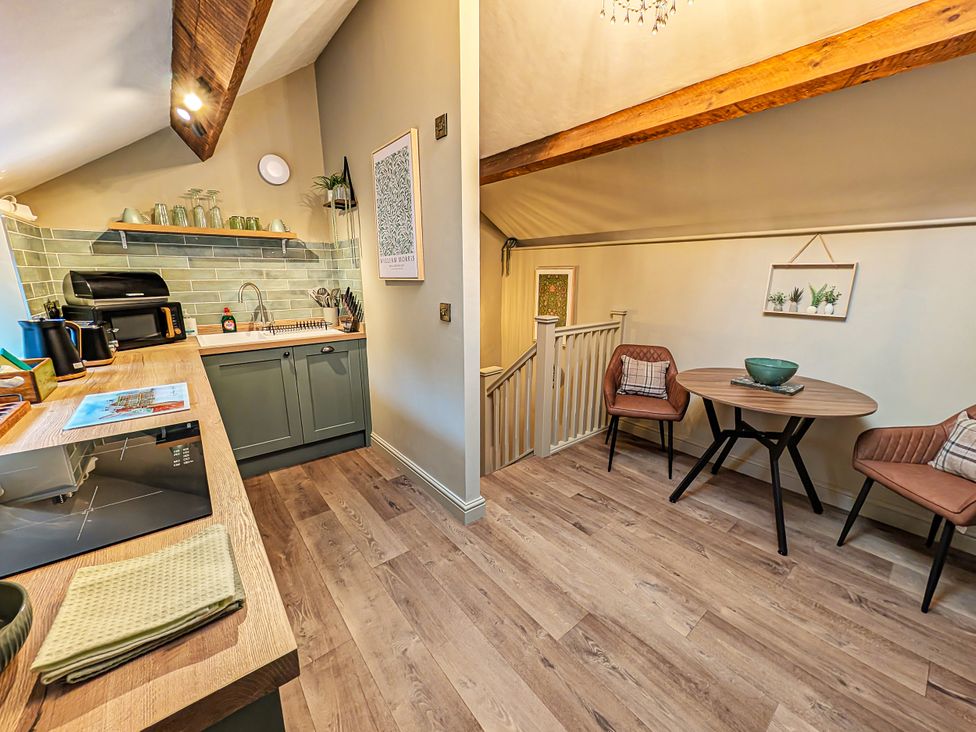 A kitchen with a table and chairs at The Gardeners Cottage in Lytham St. Annes