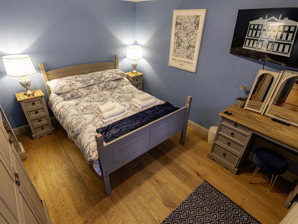 A bedroom with a bed and vanity table at The Gardeners Cottage in Lytham St. Annes